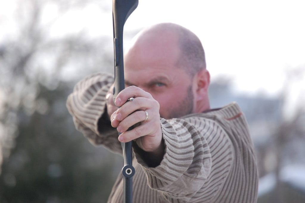 man aiming with a bow