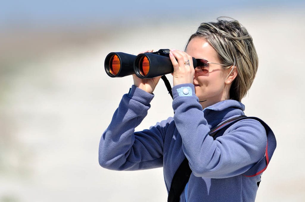 woman using binoculars with glasses