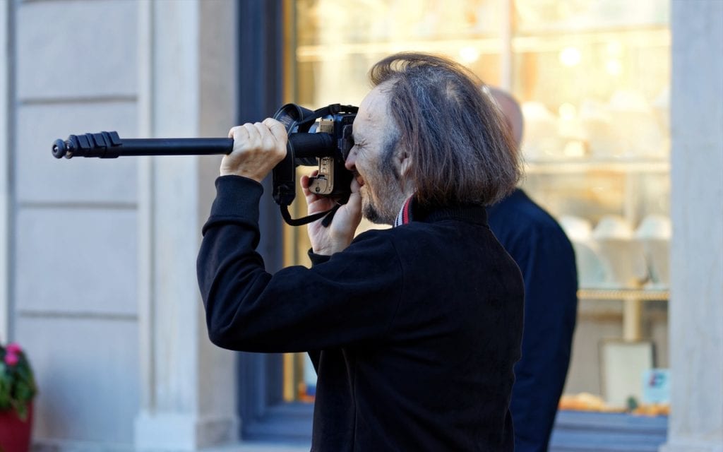 man shooting with camera on monopod