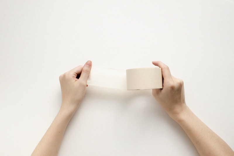 mans hand holding masking tape