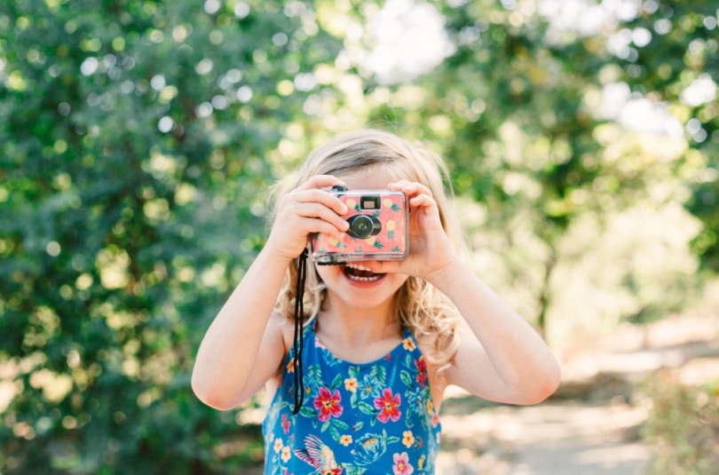 little girl using disposable camera
