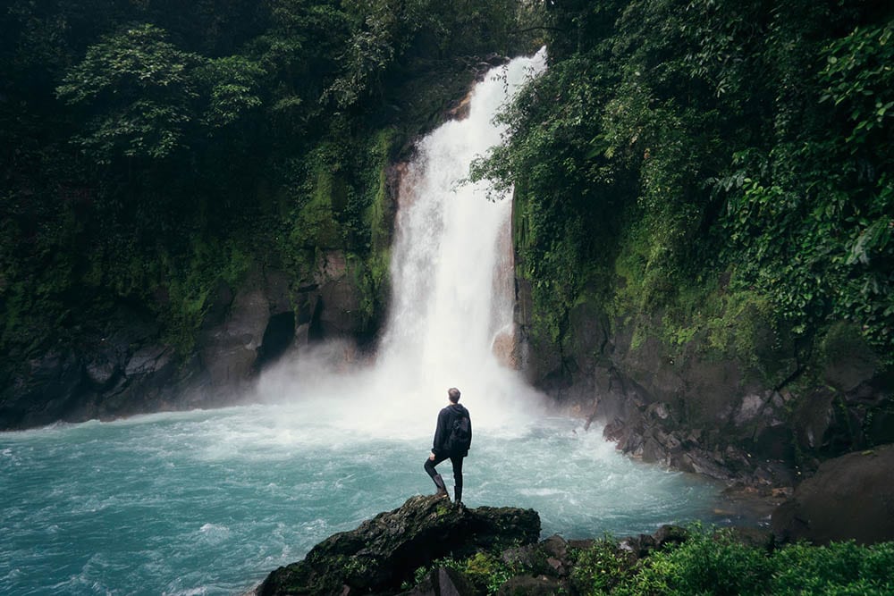 extreme long shot of a man near the waterfalls