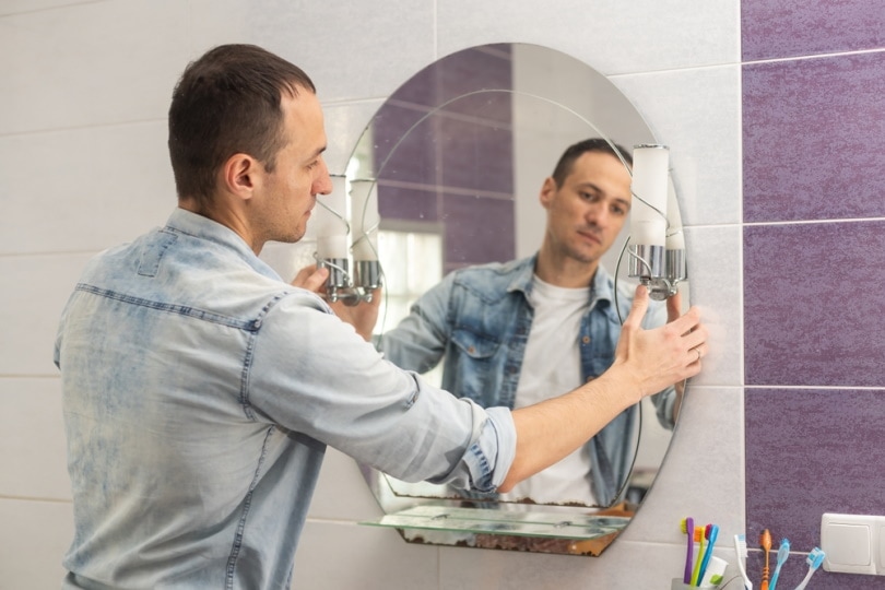 man installing mirror