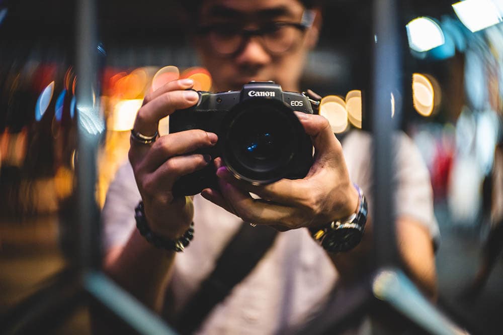 man taking a photo on the mirror using Canon EOS RP