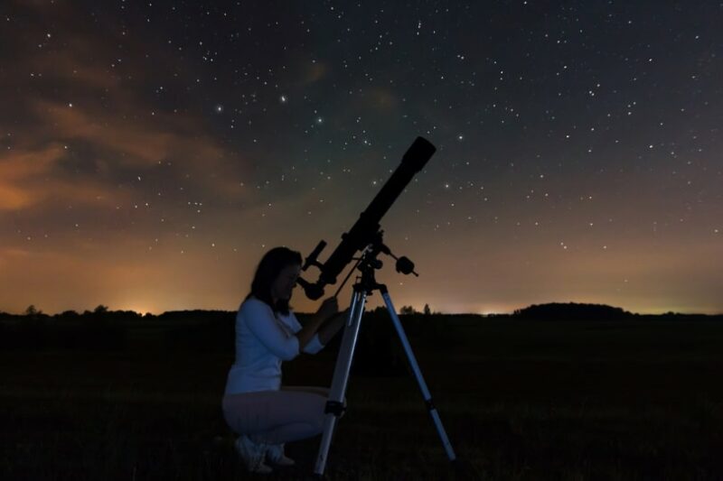 woman watching stars using telescope