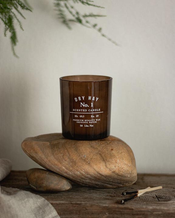 a jar of scented candle on the top of stones