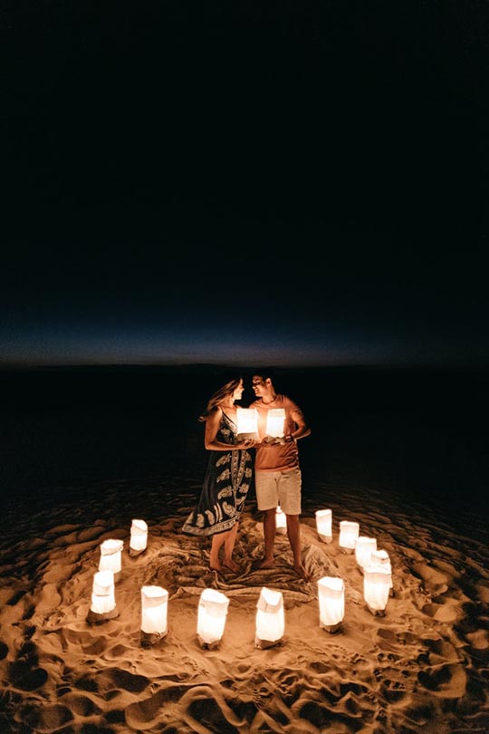 couple surrounded with candlelights at the beach