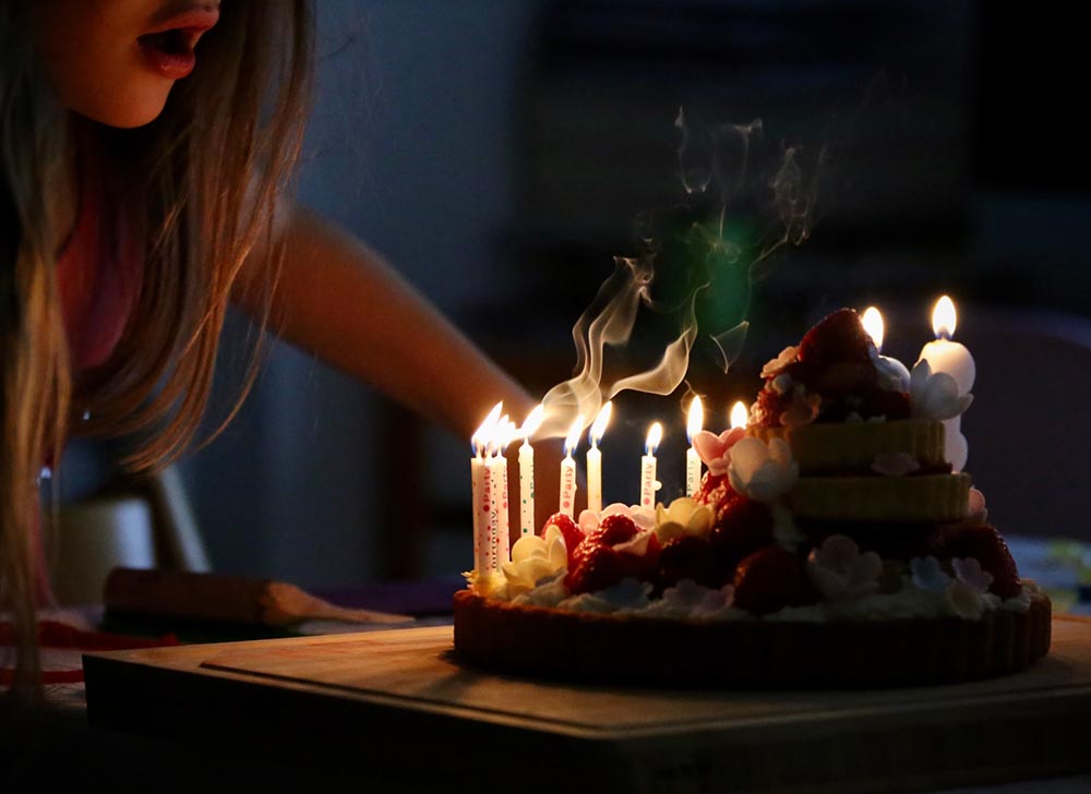 woman blowing candles of her cake