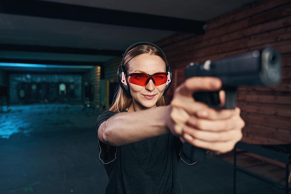 woman wearing red shooting glasses