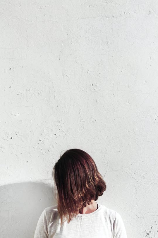 woman with short hair on white wall