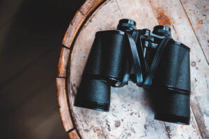 binoculars on a wooden table