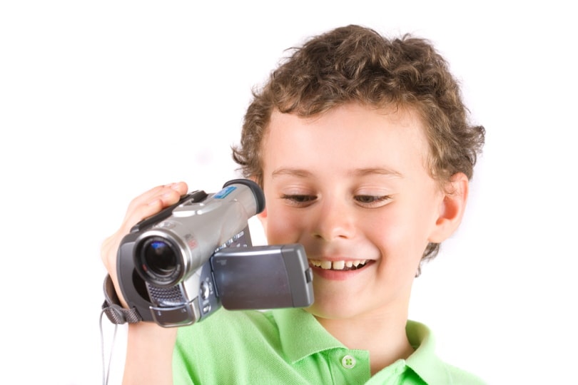 cute little boy using camcorder