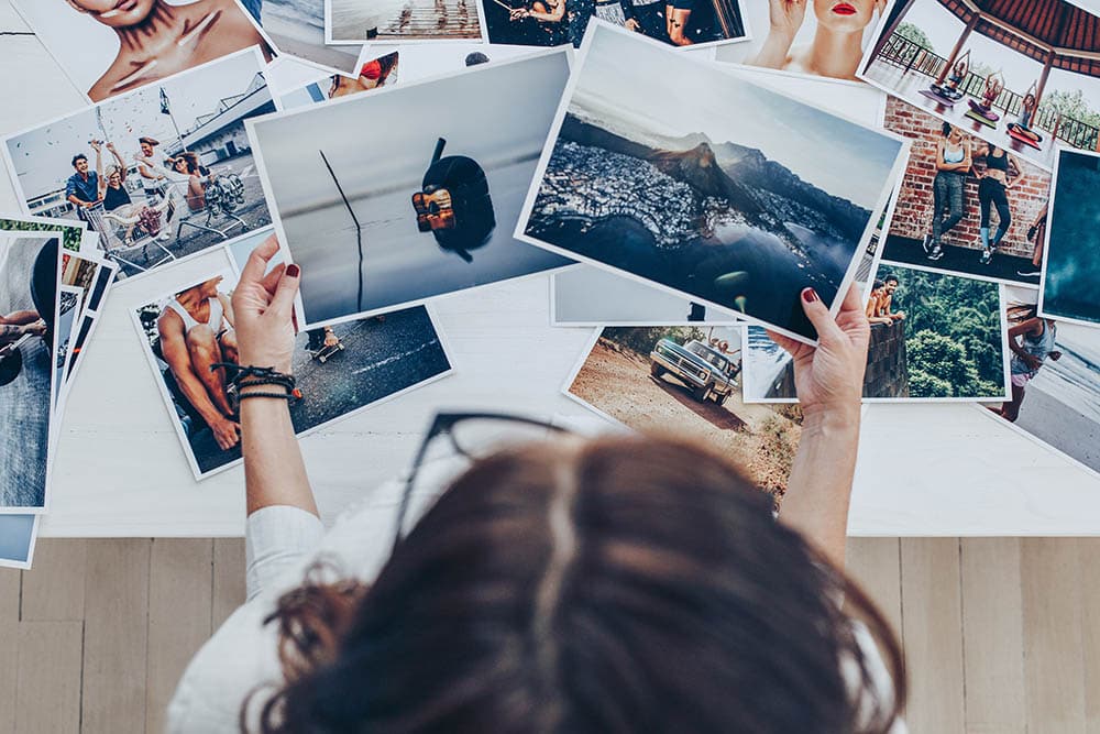 female photographer holding image prints