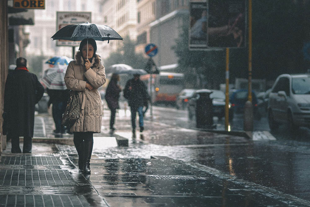 people walking down the street while raining