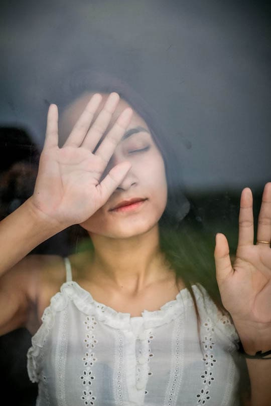 young woman on a glass window pane