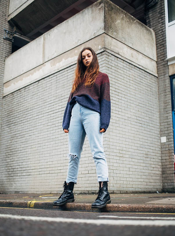 young woman standing on the side of a street