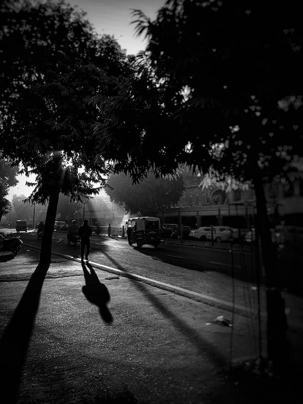 black and white photo of sun beaming in the street