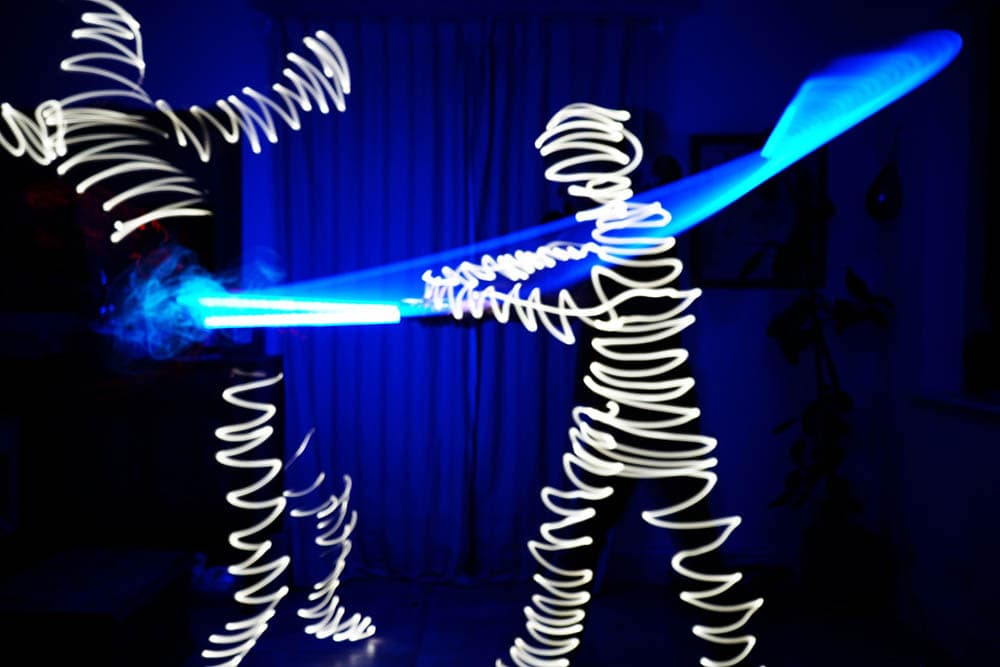 light painting of two people fighting with light saber