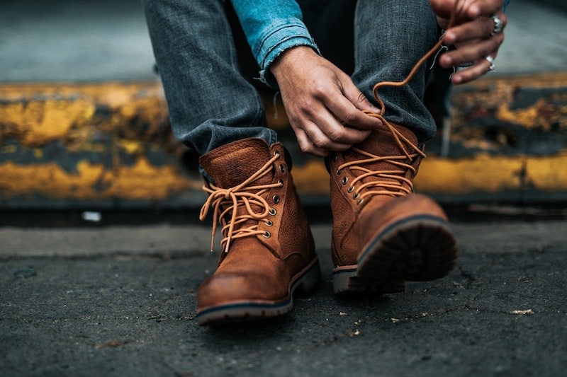 man tying hiking boot laces
