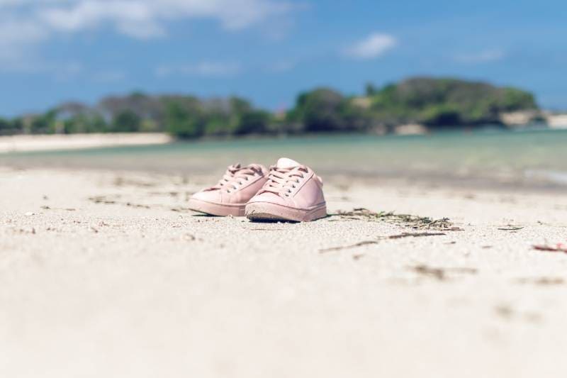 pink shoes on sand