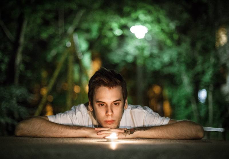 young man looking at a candle