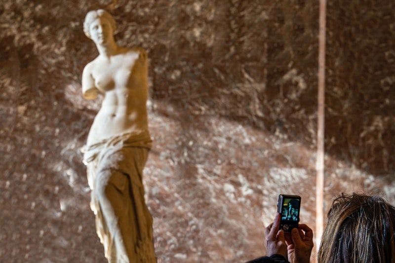 Woman taking photo of a sculpture