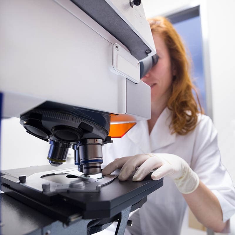 female scientist using fluorescent microscope