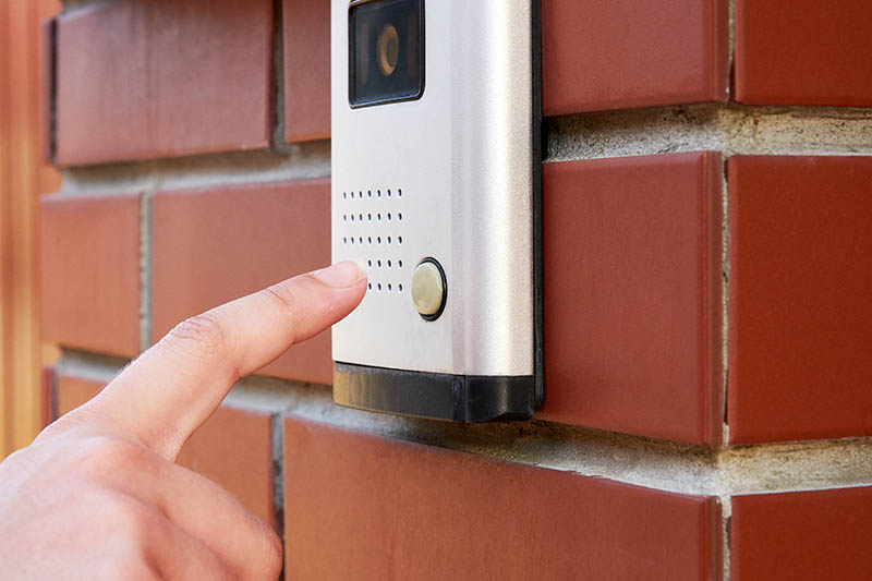 finger to press doorbell with camera