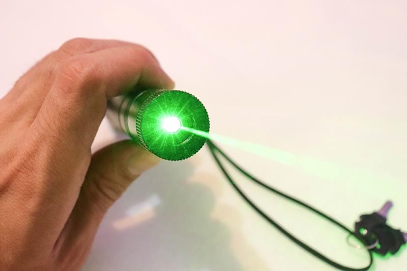 hand holding green laser pointer