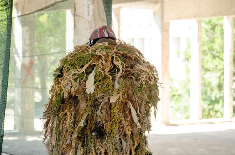 man wearing a ghillie suit or blanket