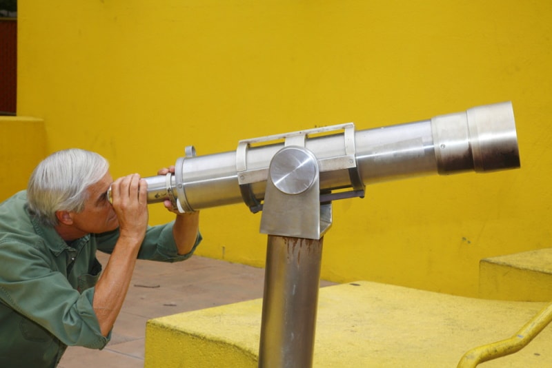 old man using telescope