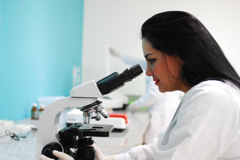 woman using microscope in laboratory