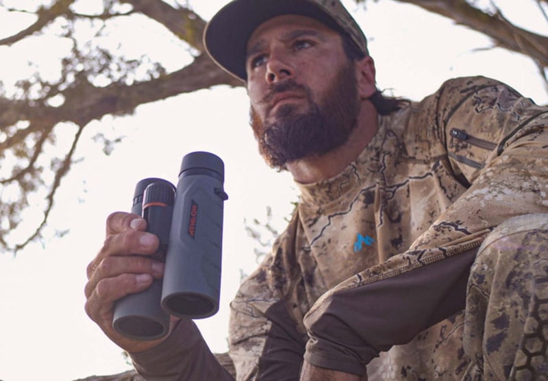 man holding the Athlon Optics 10x42 Neos G2 HD Binoculars