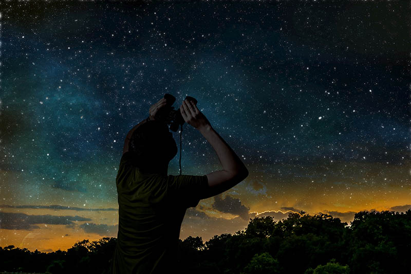 man stargazing using binoculars